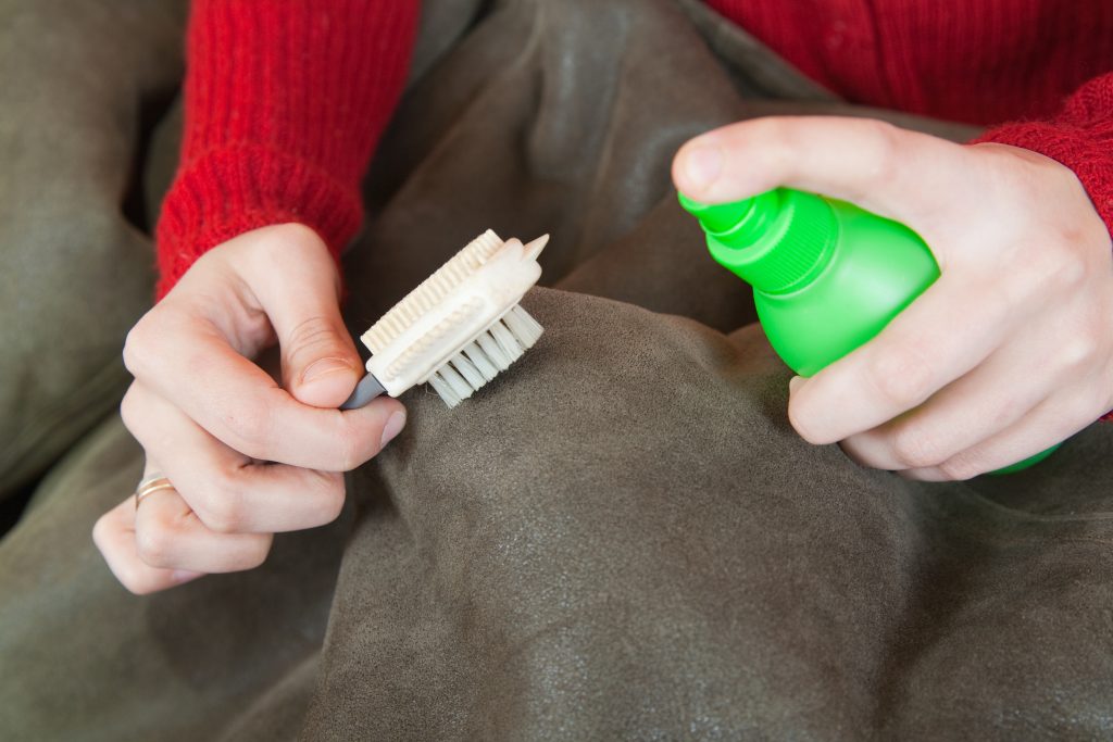Closeup of Woman cleaning a sheepskin with whisk broom