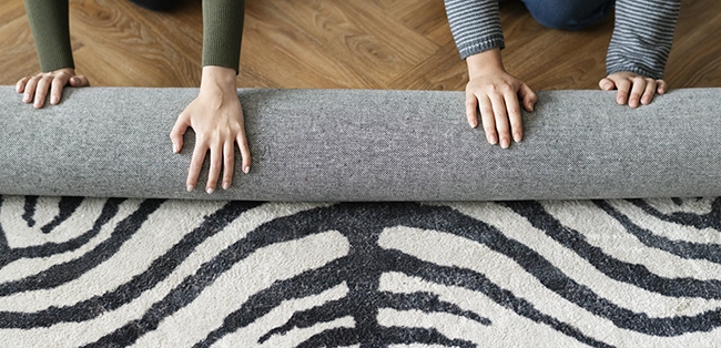 people rolling up the area rug